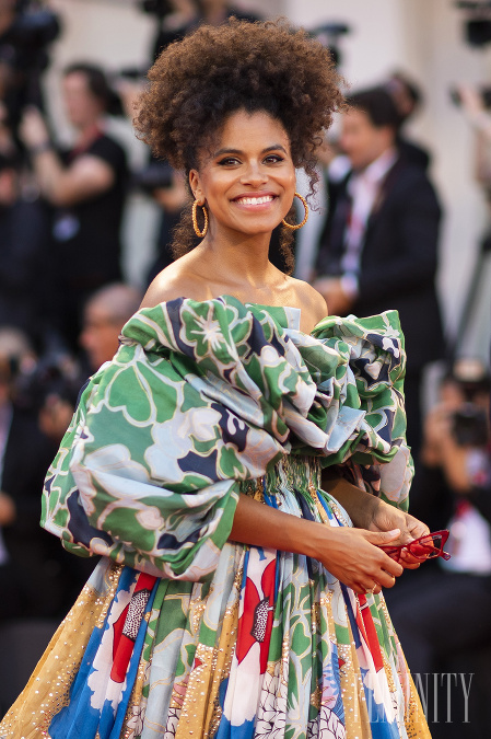 Zazie Beetz sa na premiére predviedla v pestrofarebných šatách s odhalenými ramenami a nazberkanými rukávmi. 